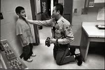 A police officer kneeling down to talk to a child.