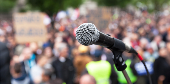 A microphone is pointed at the crowd of people.