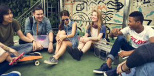 A group of young people sitting on the ground.