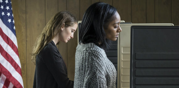 Two women standing next to each other in front of a computer.