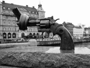 A gun statue in the middle of a river.