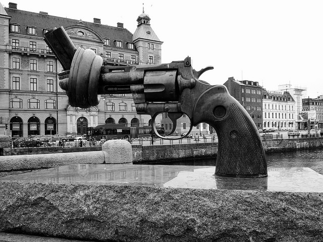 A gun statue in the middle of a river.