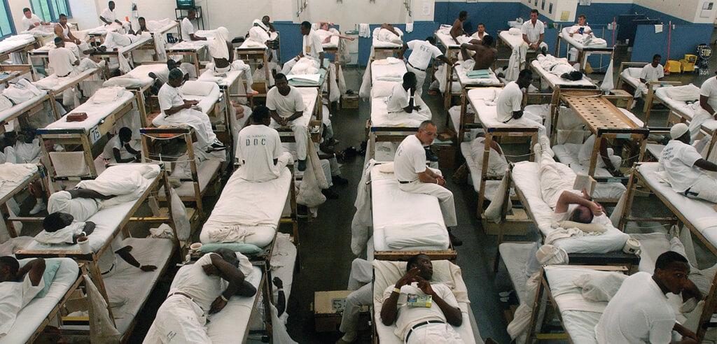 A group of people in white uniforms sitting on top of beds.