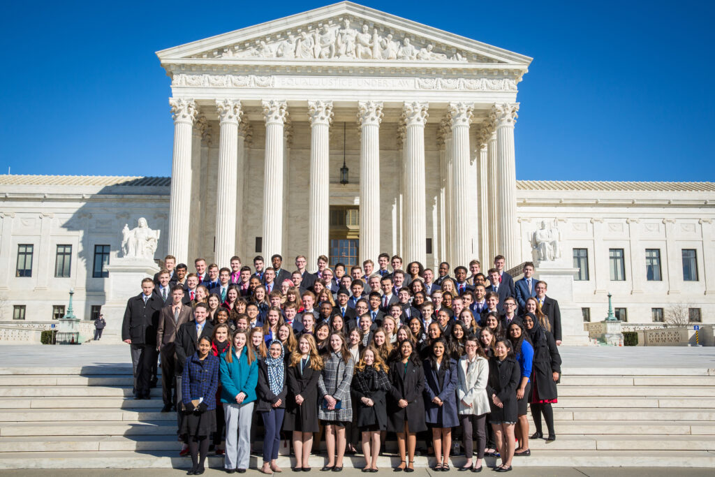 A group of people standing in front of the supreme court.