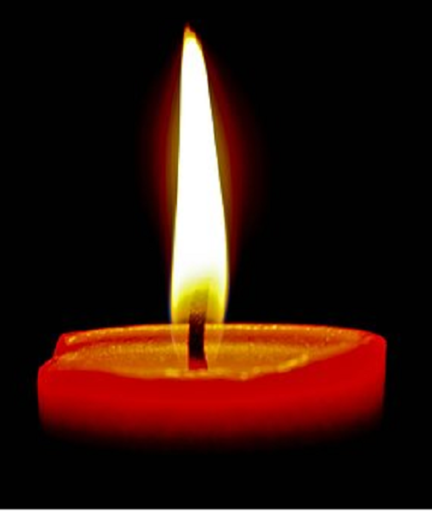 A candle is lit on the dark background